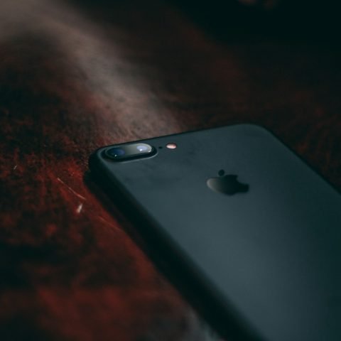 black iPhone 7 on brown surface