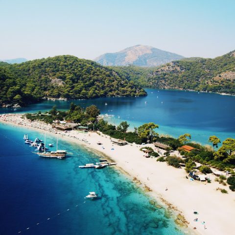aerial photography of yachts on blue sea viewing mountain under blue and white skies during daytime
