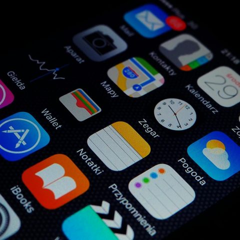 Close-up view of smartphone displaying various apps on the home screen.