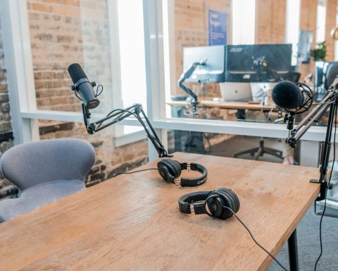 two black headphones on brown wooden table