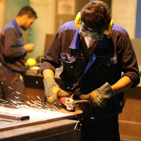 man in black long sleeve shirt holding gray metal tool