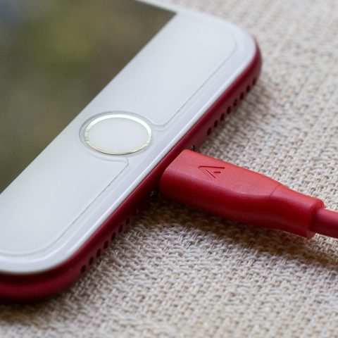 Smartphone die oplaadt via een kabel op een bureau