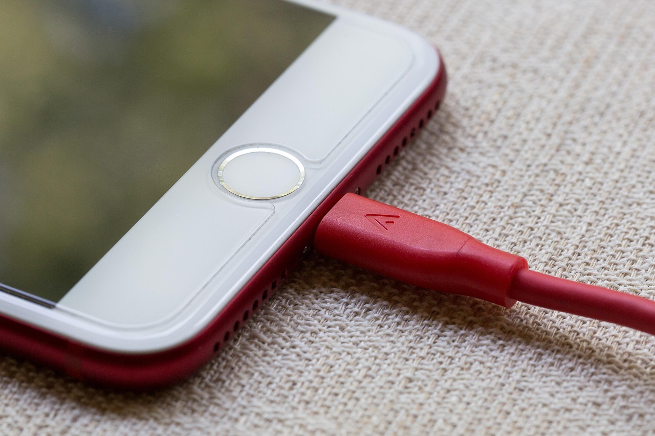 Smartphone die oplaadt via een kabel op een bureau