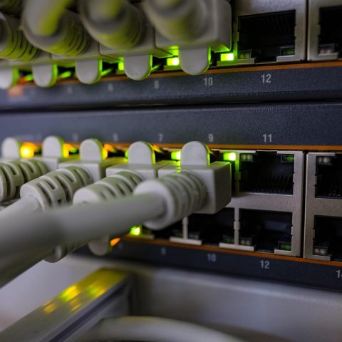 Een netwerkswitch met meerdere ethernet-kabels aangesloten in een thuisnetwerk