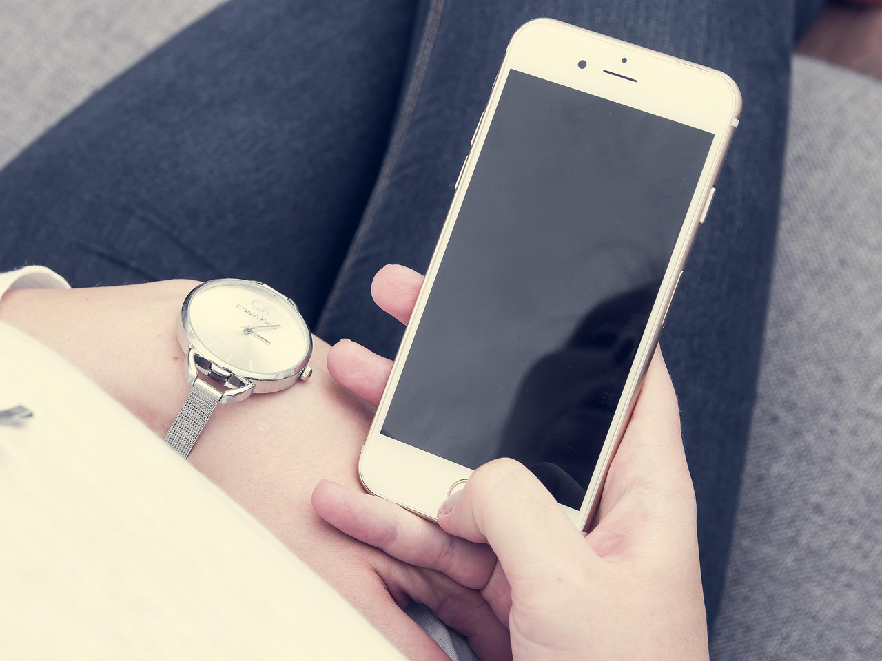 Persoon die 's avonds in een donkere kamer op een smartphone kijkt