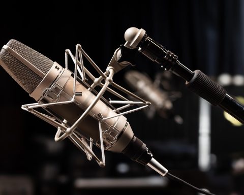 Thuisstudio met laptop, audio-interface en microfoon op een bureau