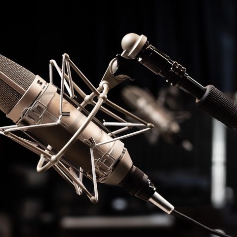 Thuisstudio met laptop, audio-interface en microfoon op een bureau