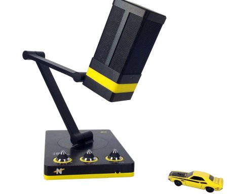 Een USB-microfoon op een bureauarm naast een monitor, klaar voor gebruik tijdens thuiswerk of streaming