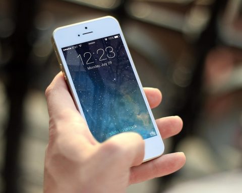 Smartphone met hoesje en screenprotector naast elkaar op een tafel
