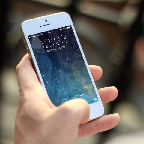 Smartphone met hoesje en screenprotector naast elkaar op een tafel