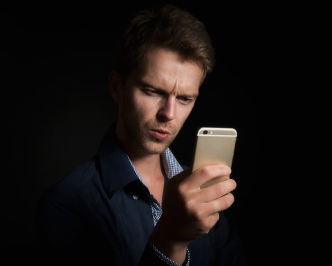 Persoon die nieuws leest op een smartphone, met meerdere apps zichtbaar op het scherm