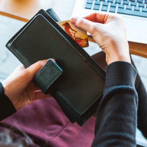 Een persoon die op een laptop een webshop bekijkt met een keurmerklogo zichtbaar op het scherm