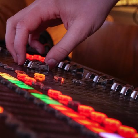 Een thuisstudio opstelling met een audio-interface, microfoon en laptop op een bureau