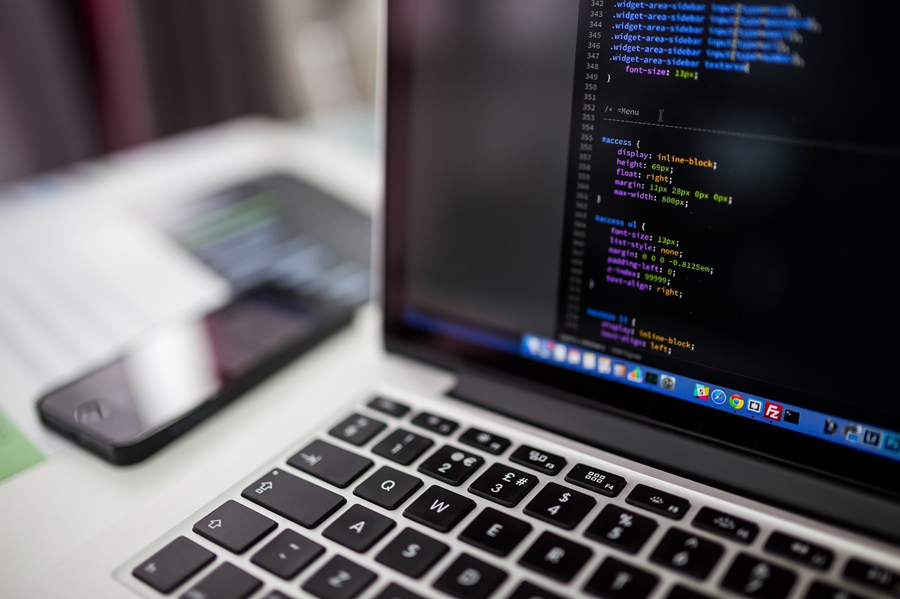 Een persoon die achter een laptop code schrijft en beveiligingslekken onderzoekt