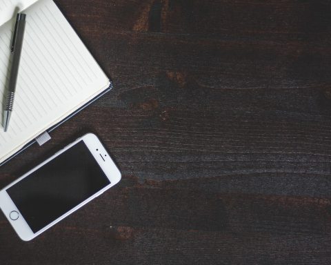 Diverse iPhone-accessoires zoals een oplader, kabel en MagSafe-wallet op een bureau