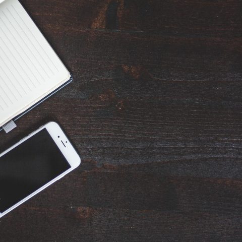 Diverse iPhone-accessoires zoals een oplader, kabel en MagSafe-wallet op een bureau