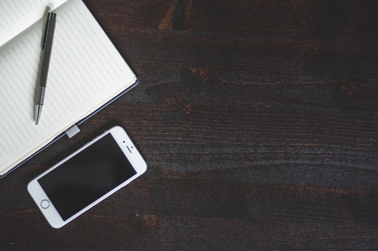 Diverse iPhone-accessoires zoals een oplader, kabel en MagSafe-wallet op een bureau