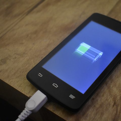 Technicus vervangt de batterij van een smartphone op een reparatietafel