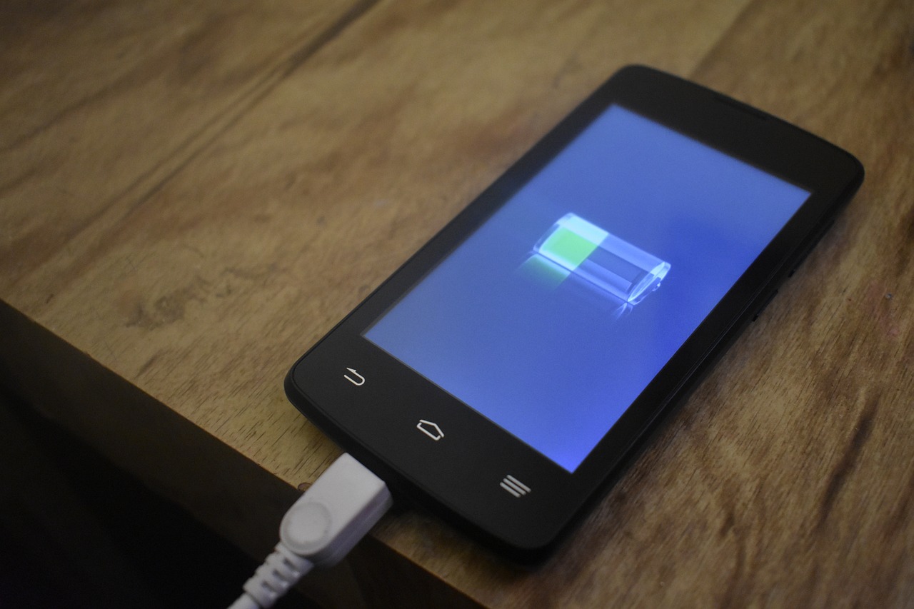 Technicus vervangt de batterij van een smartphone op een reparatietafel